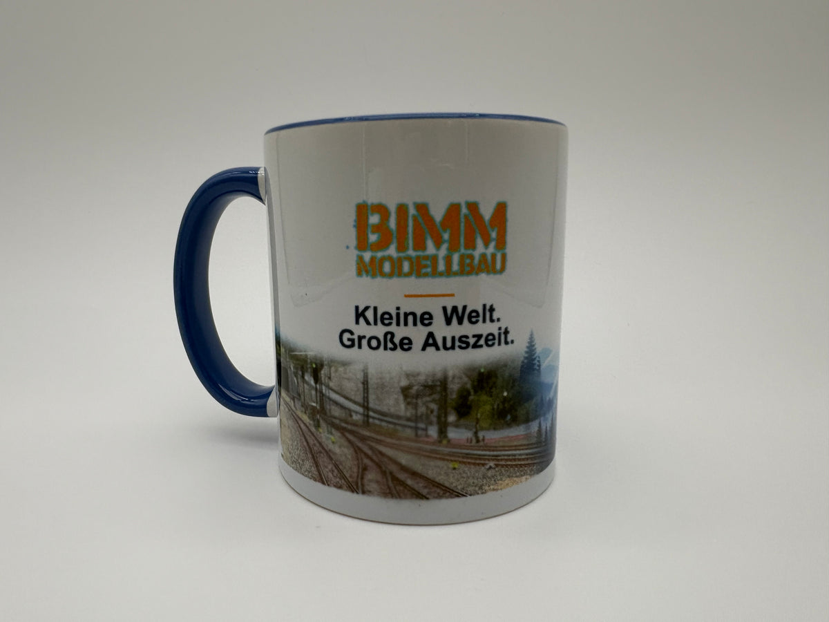 BIMM Modellbau Sammeltasse Blau – Vorderseite mit Logo und Modellbahnmotiv
