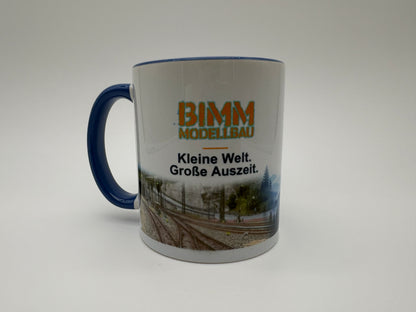 BIMM Modellbau Sammeltasse Blau – Vorderseite mit Logo und Modellbahnmotiv
