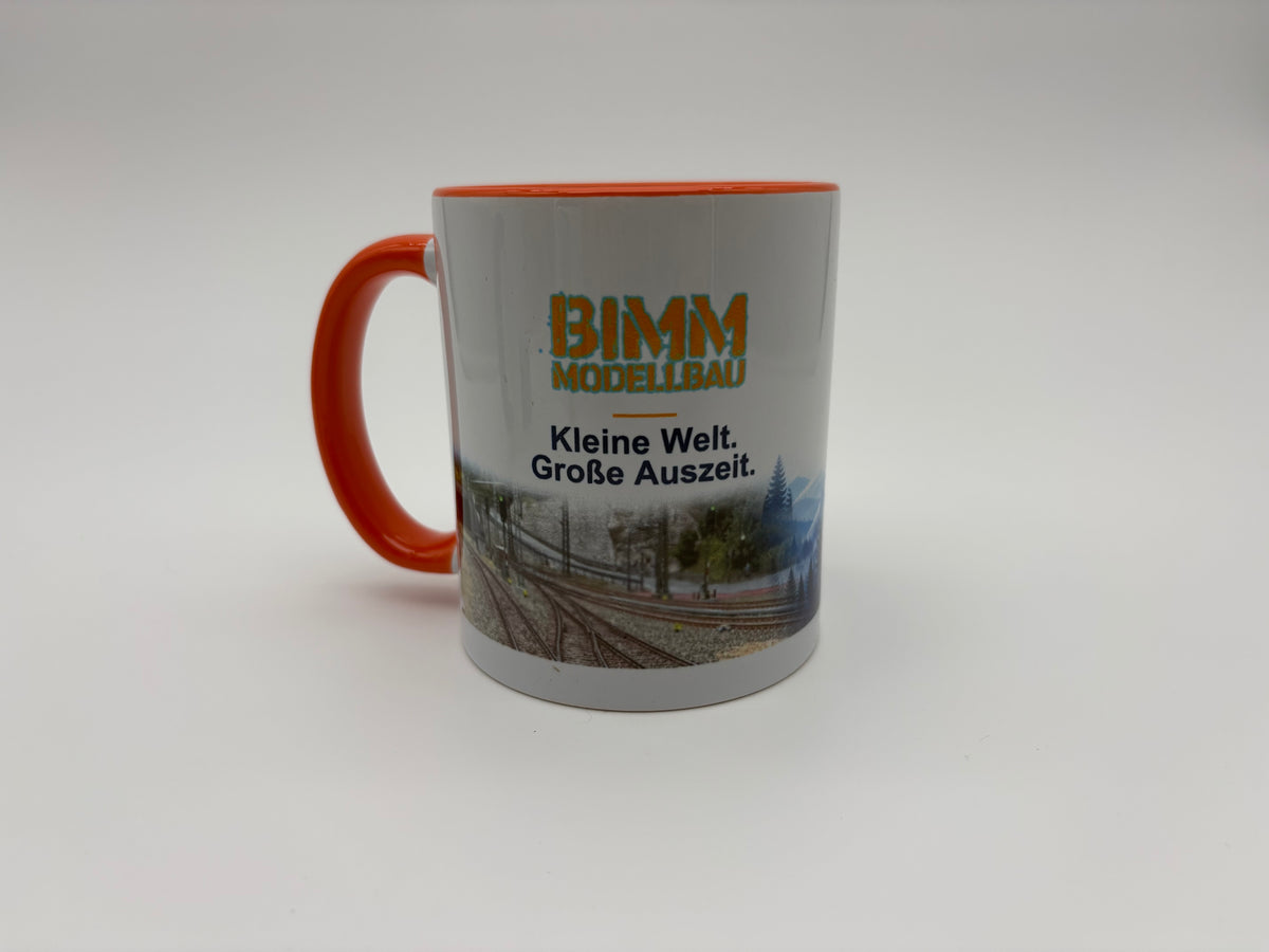 BIMM Modellbau Sammeltasse Orange – Vorderseite mit Logo und Modellbahnmotiv